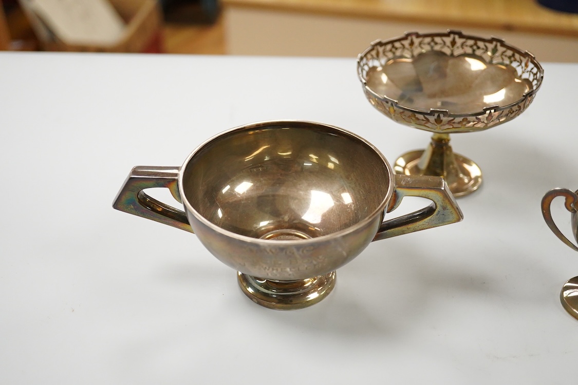 Five assorted George V silver trophy cups including two tri-handled, approx. 12.2cm and a silver bon-bon dish, with pierced border, 19.3oz.